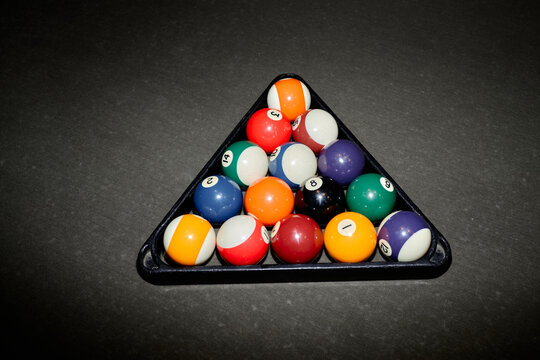 Overhead shot of billiard balls resting in triangle rack on pool table, presenting game setup and leisure competition concept. Useful for sports marketing, bar promotion, entertainment ads
