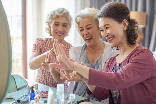Senior female friends try out new cosmetics and beauty products