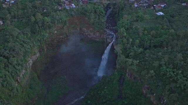 Aerial view of kabut pelangi waterfall flowing in the java forest