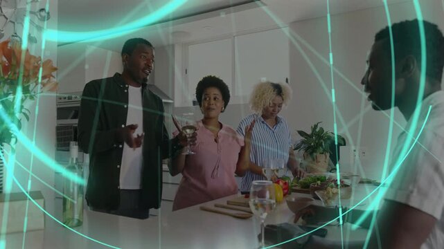 Standing man speaking, group prepping food and socializing, passing wine glass, teal overlay moving