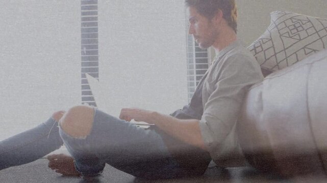Mid-adult man in tech starting typing on laptop, backlight glare crossing screen then clearing