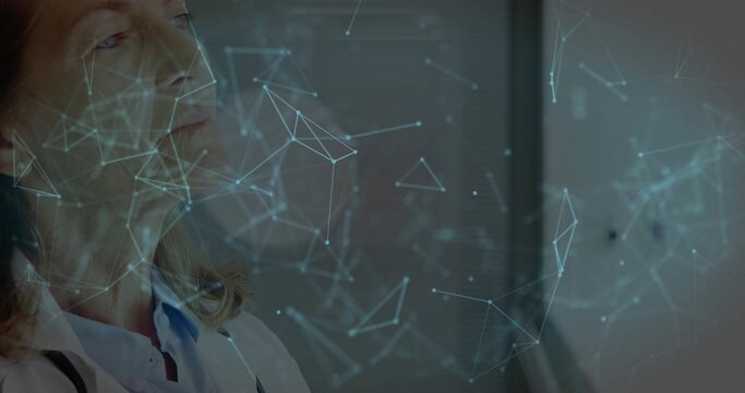 Gazing senior doctor viewing network at clinic, wearing white lab coat and stethoscope, copy space