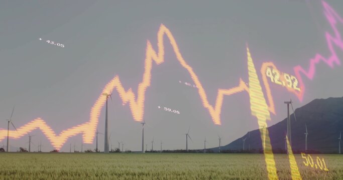 Framing wind turbines spinning over field with mountain ridge, showing glowing stock chart numbers