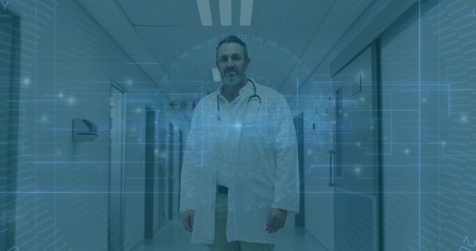 Standing mature physician wearing white coat and stethoscope in hospital corridor, blue HUD overlay