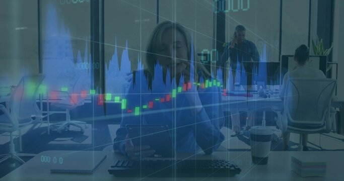 Talking businesswoman in blouse typing at keys and holding phone at office desk with market charts