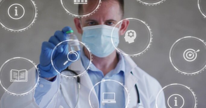 Doctor wearing lab-coat mask and blue-glove holding vial with green cap in clinic with overlays