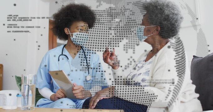 Consulting nurse in blue scrubs with tablet, sitting with patient home, with stethoscope and masks