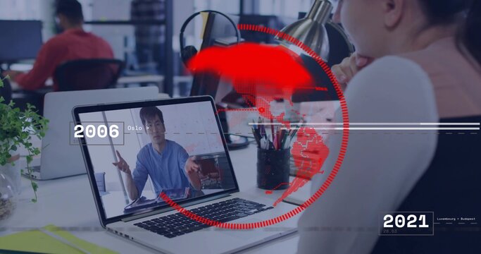 Watching man in blue shirt gesturing on laptop in office, with red world-map overlay 2006 2021