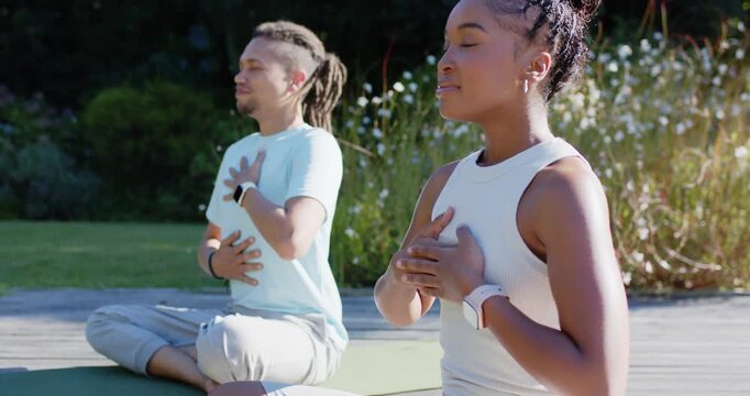 Couple following breath cues, practicing breathing hands on chest and belly on deck mats for calm
