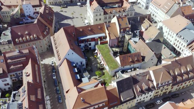 Modern House with green grass roof ecological Aerial view of historic courtyards in Pirna's old town featuring red tiled roofs and a modern green roof in sunny weather.