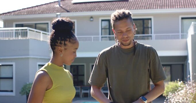 African descent couple arriving at deck sun drawing man placing panel while woman showing phone