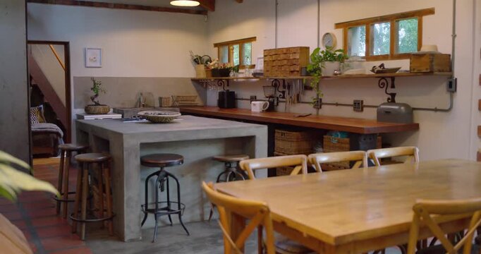Camera is starting slow right pan at shot start to showcase concrete island in farmhouse kitchen