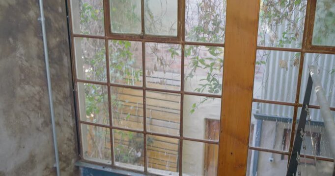 Camera is tilting downward to reveal cast-iron spiral staircase and terracotta tiled courtyard