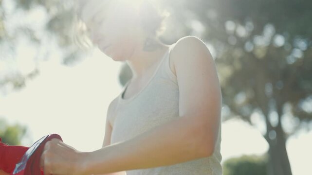 Tattooed woman preparing slackline equipment outdoors