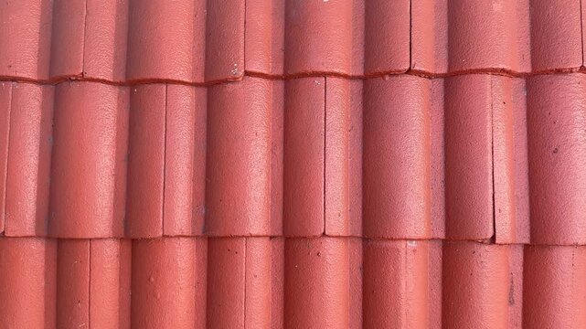 Video of red ceramic roof tiles in curved pattern rows, textured construction surface with warm terracotta tones