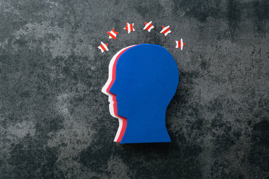 Stylized silhouette of a human head in profile, made in the colors of the American flag on a concrete background. Creative concept of American patriotism, July 4th celebration. Independence day.