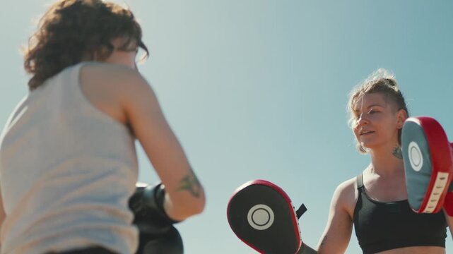 Women boxing and training together on a sandy beach