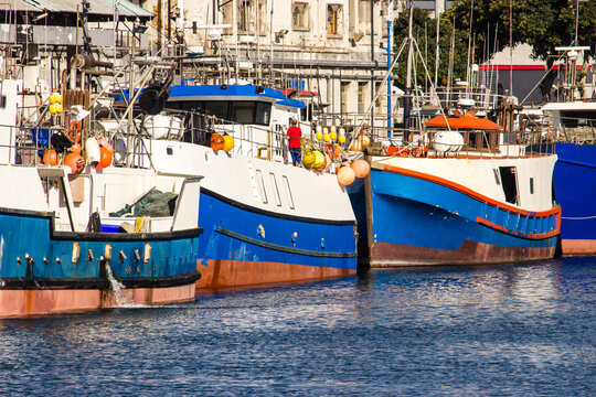 Blue, red and white fishing boats docked at the harbour at the V&A waterfront in Cape Town, South Africa.