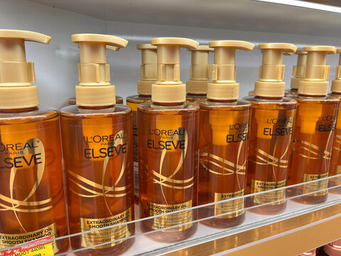 Row of L'Oreal Elseve hair care products displayed on a store shelf. The bottles are amber-colored with pump dispensers. Products are designed for hair nourishment and beauty.