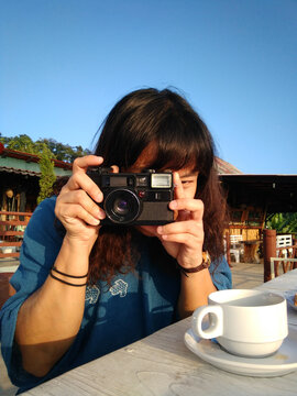Happy Asian woman taking a photo with analog film camera with travel and journey