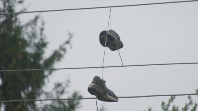 Shoes hanging on power lines in a residential area during the daytime in spring