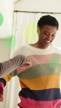 Vertical video: Woman in sweater taking hand, fistbumping and celebrating, green overlay social