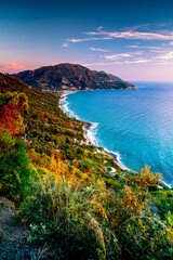 Vertical mountainous coast of Corfu Island with green shoreline at sunset. Viewpoints in Greece. © Tomasz