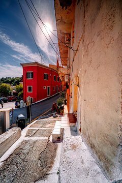 Vertical photo of street in town Pelekas on island Corfu with colorful historic architecture, Greece.