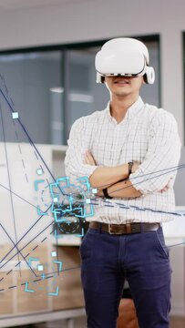 Vertical video: Male dev wearing VR set tilting head and starting moving blue AR graphs for IT test