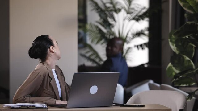 Professionals collaborating on new project using laptop in shared workspace. Productivity concept.
