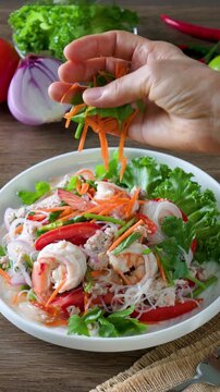 Spicy glass noodles with minced pork and shrimp on a wooden