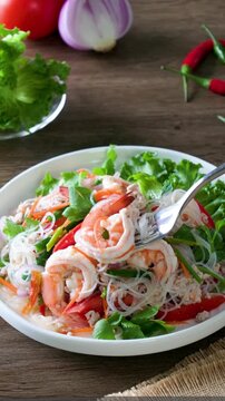 Spicy glass noodles with minced pork and shrimp on a wooden