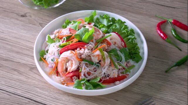 Spicy glass noodles with minced pork and shrimp on a wooden