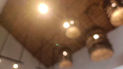 Fototapeta premium Blurred image of lights on a wooden ceiling in a room