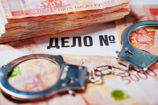 Handcuffs on rubles and case file, corruption and crime concept