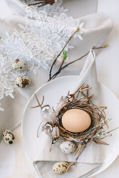 Close-up overhead view of an Easter place setting decorated with an egg in a bird's nest on a dining table