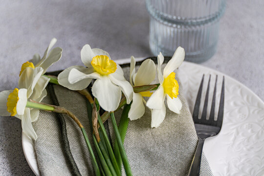 Close-up of a spring place setting with fresh daffodils on a table