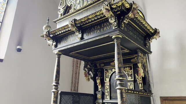 Ornate black wooden pulpit in church interior