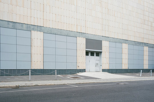 Modern architecture facade framing an empty urban street over concrete pavement with minimal infrastructure details and calm minimalist city mood