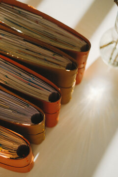 Notebook stack in warm light, aged leather covers and textured pages, closeup on bindings, study setup with journals and writing mood, creative workspace ambience