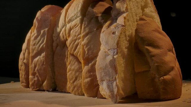 Close up of freshly sliced bread lined up on a wooden surface. Concept of homemade food, bakery products, content for bakeries and bread factories, store, supermarket, gastronomy and culinary art