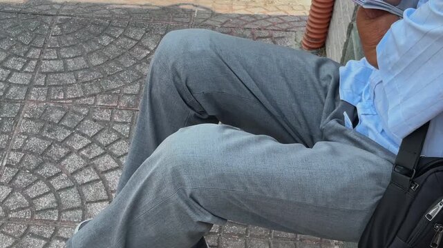 The strength of human spirit: An armless street vendor meticulously preparing his daily work on a Vietnam sidewalk