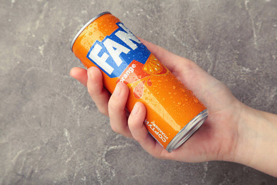 Mykolaiv, Ukraine - March 25, 2026: Female hand holds Fanta can on grey concrete background.