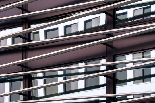 Modern building facade with louvers and windows casting shadows in clean lines creating an abstract pattern for contemporary architecture backgrounds