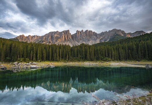 Latemar group reflected in the Karersee, Lake Carezza, cloudy skies, mountain peaks, Eastern Latemar Peak, Diamond Tower, Col Coron,  Nova Levante, Bolzano, South Tyrol, Italy