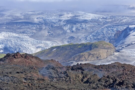 View across new lava fields created by a volcanic eruption in 2010 to the Myrdalsj&ouml;kull glacier, at the long-distance hiking trail from Sk&oacute;gar via Fimmv&ouml;r&eth;uhals to the Th&oacute;rsm&ouml;rk mountain ridge, &THORN;&oacute;rsm&ouml;rk, Iceland