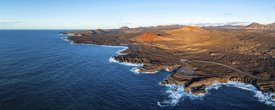 Coast with lava fields, volcanic landscape near Los Hervideros with red volcano Monta&ntilde;a Bermeja, in the evening light, aerial view, Lanzarote, Canary Islands, Spain