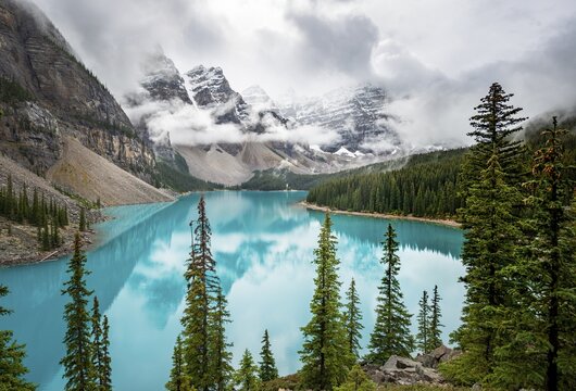 Cloudy mountain peaks, reflection in turquoise glacial lake, Moraine Lake, Valley of the Ten Peaks, Rocky Mountains, Banff National Park, Alberta Province, Canada