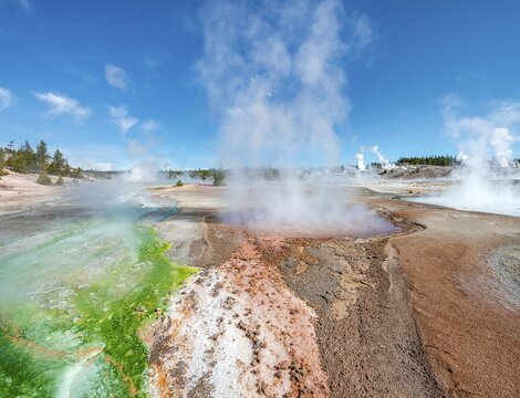 Red mineral deposits and green algae at a thermal spring, steaming hot springs, Whirligig Geyser, Noris Geyser Basin, Yellowstone National Park, Wyoming, USA