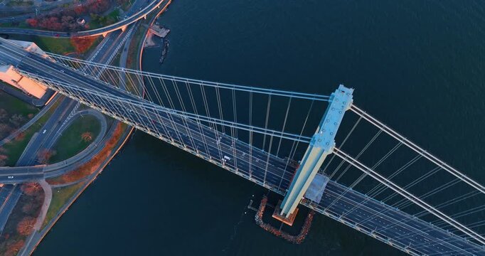 Rising high over the striking Verrazzano-Narrows Bridge. Transport moves by the bridge and highways at the waterfront.
